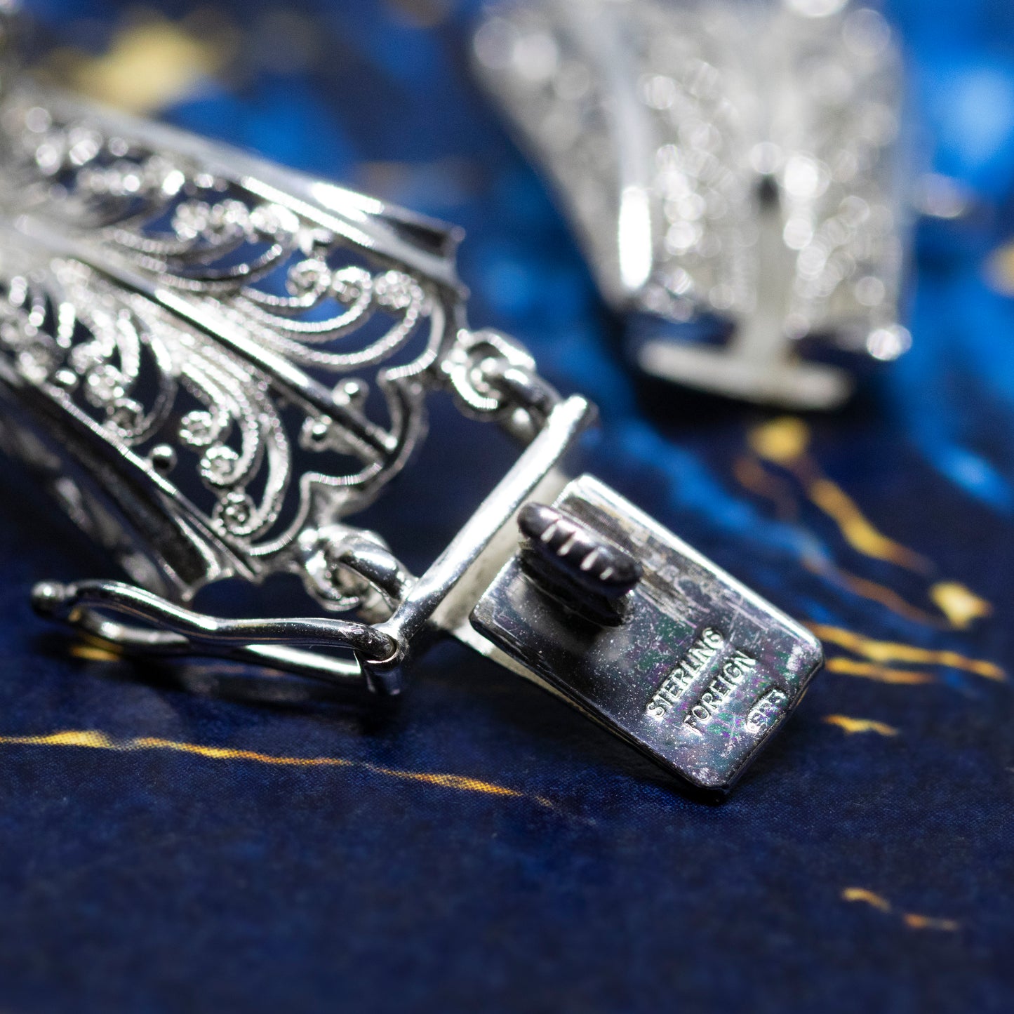 A close-up of the bracelet clasp, stamped with a mark that reads "Sterling Foreign 925".