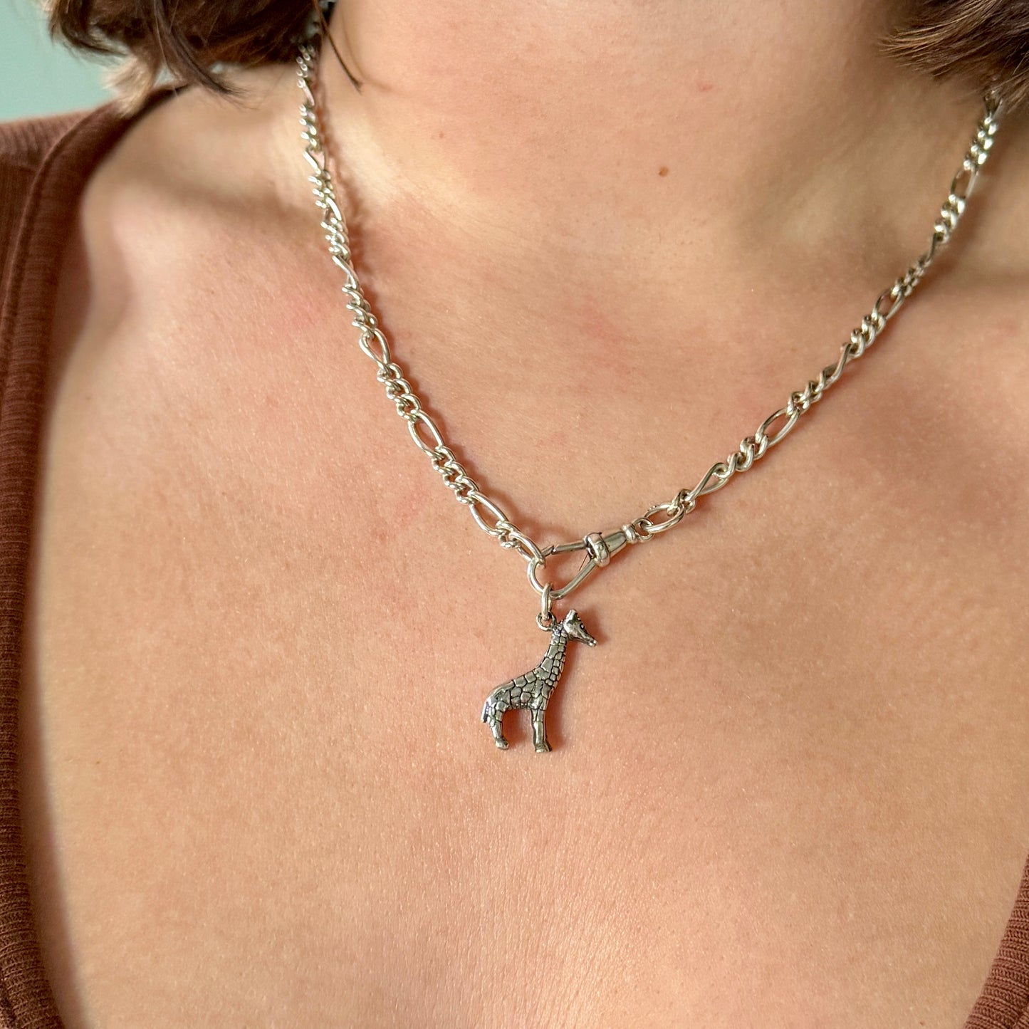Necklace with a giraffe pendant worn by a person